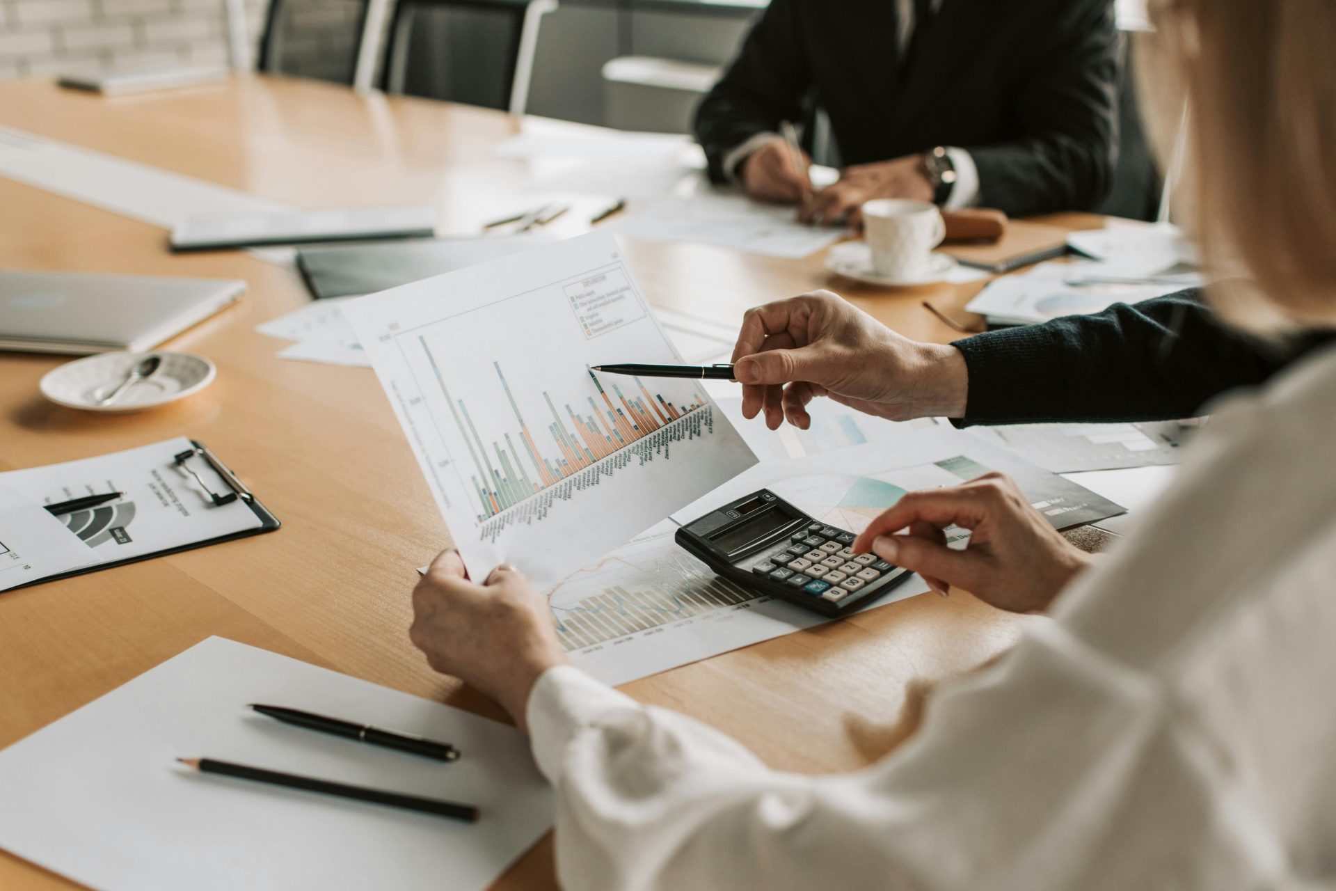 Fachleute analysieren während einer Besprechung Finanzgrafiken und -diagramme.